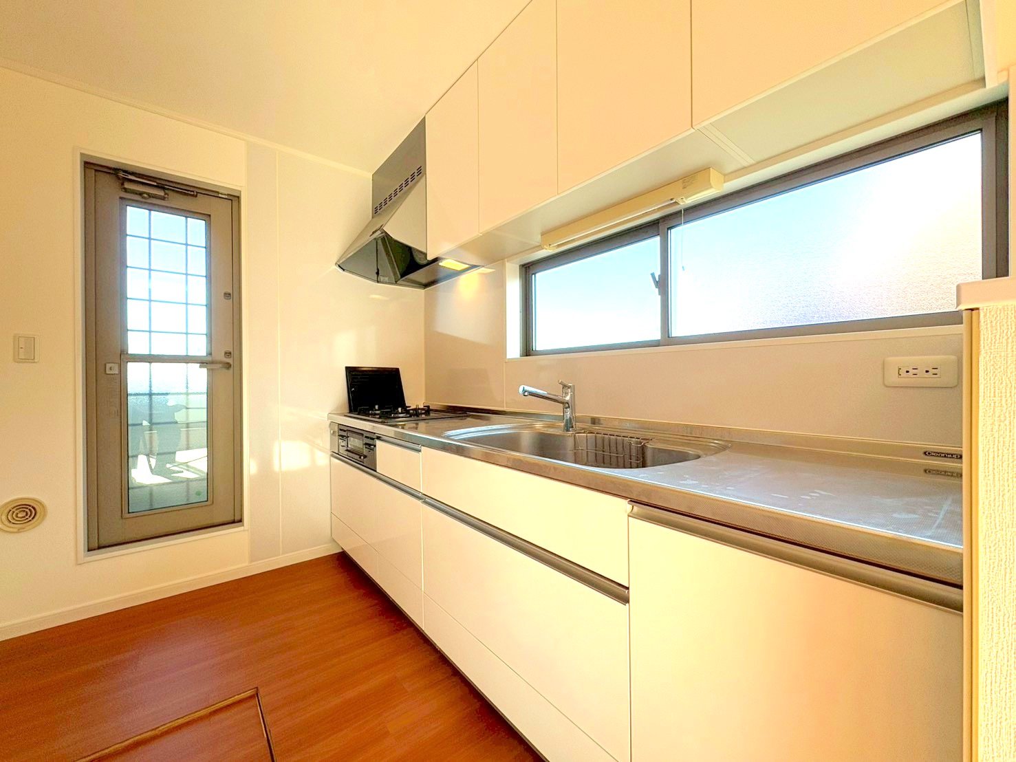 窓から外の光を通す明るいキッチン。キッチン側にもバルコニーがございます。