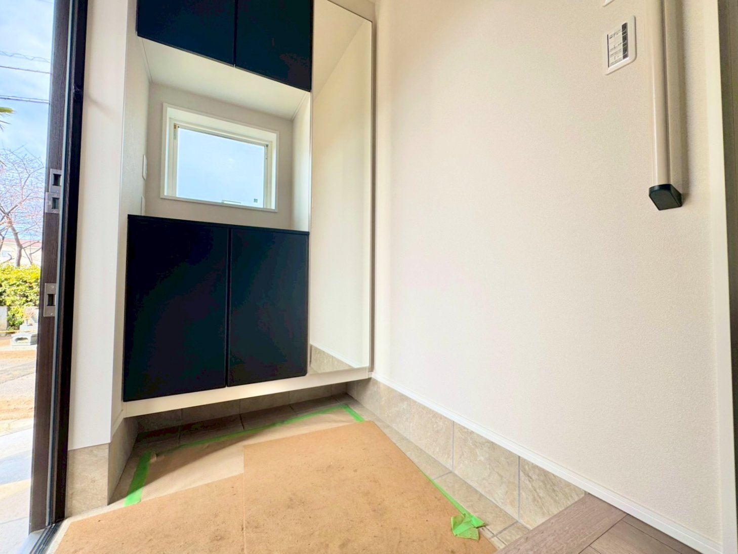 窓から外の光を通す、明るく広い玄関。