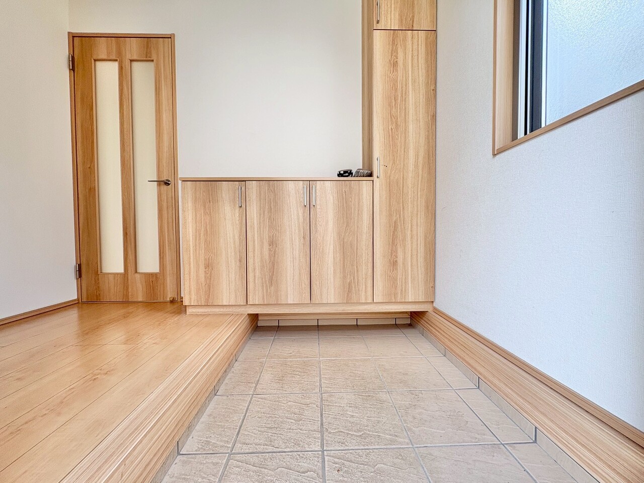 窓から外の光を通す、明るく広い玄関。