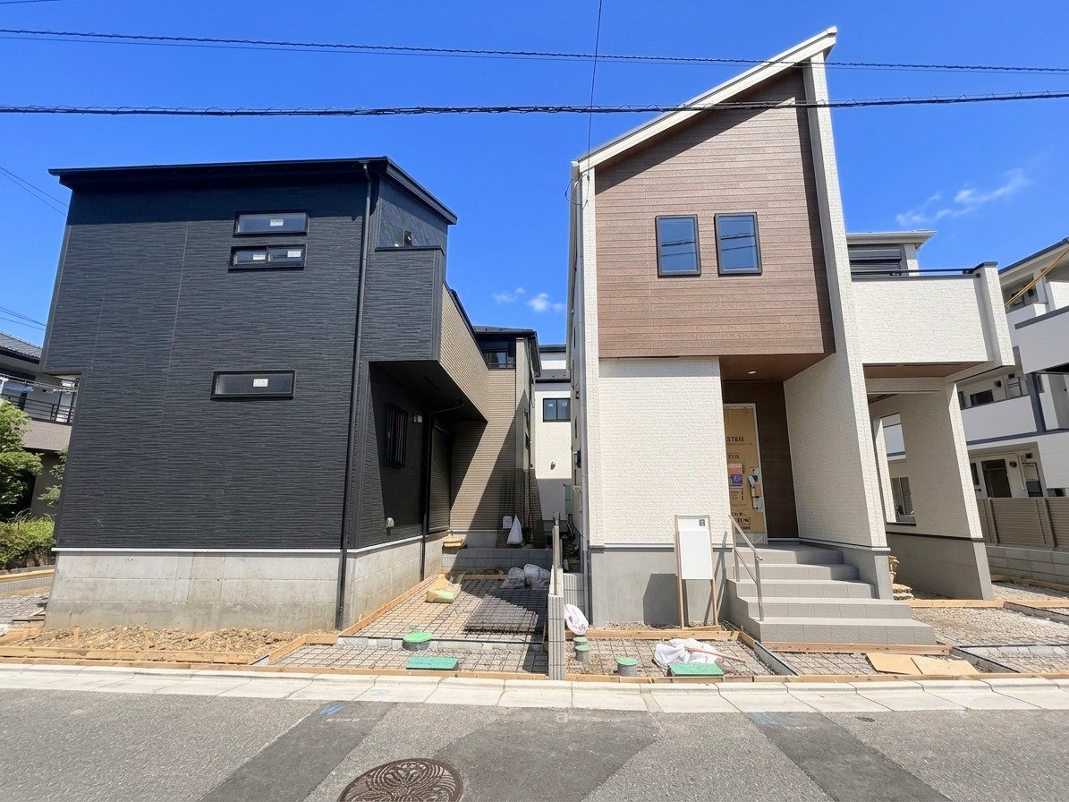 左が当物件。開放感のある角地に面した邸宅。(令和8年7月撮影)