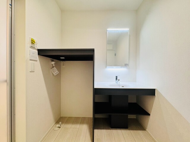 【1号棟】<br>LED照明のくもり止め仕様。ミラー扉の内側がすべて収納スペースになっており、下棚は使い勝手の良いオープン収納♪のスライド画像