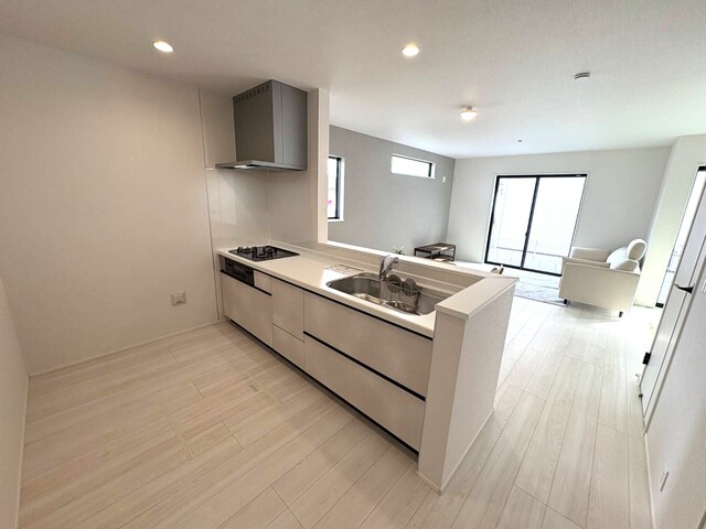 ①号棟<br>キッチンを照らすダウンライトを設備<br>お皿洗い中も家族と会話ができる対面キッチンのスライド画像