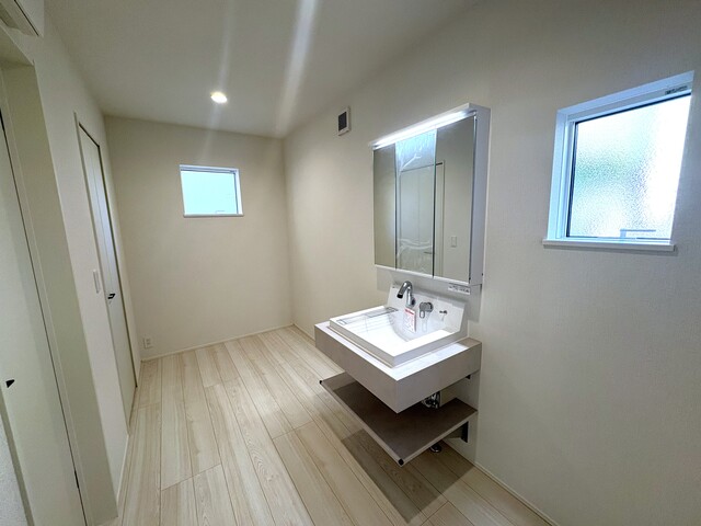 ２号棟　洗面脱衣室・ランドリースペース<br>洗面化粧台の横には室内干し可能なランドリースペースあり♪<br>天気も季節も気にせずお洗濯できますのスライド画像