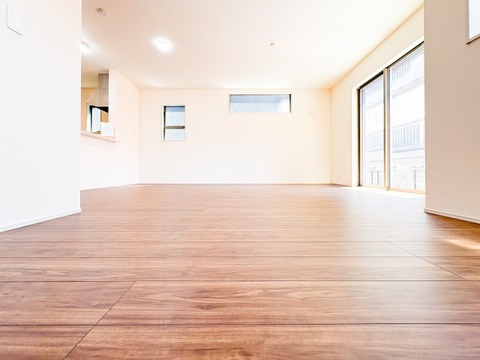高窓からの自然光が室内を明るく照らし、温かみのある木目の質感を美しく引き立てます。白を基調とした壁面とのコントラストが清潔感を演出し、一日を通して穏やかな時間が流れる、安らぎのリビング空間です。