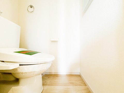 白を基調とした、清潔感あふれるトイレ空間。スリット窓から自然光が差し込み、明るく爽やかな印象を与えます。温水洗浄便座付きで、毎日を快適に過ごせる機能性もしっかりと備わっています。