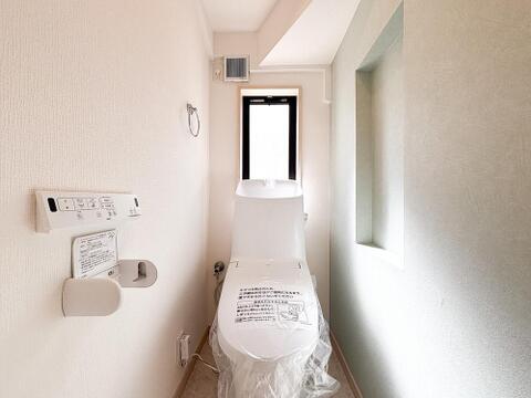 清潔感あふれるホワイトを基調とした便利な温水洗浄便座付きトイレ。窓からの自然光が差し込み、さりげないお洒落さとゆとりを演出します。