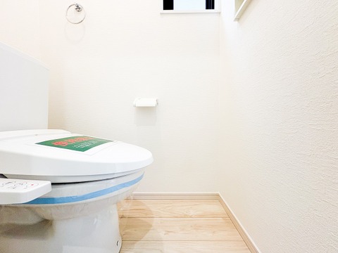 白を基調とした、清潔感あふれるトイレ空間。スリット窓から自然光が差し込み、明るく爽やかな印象を与えます。温水洗浄便座付きで、毎日を快適に過ごせる機能性もしっかりと備わっています。