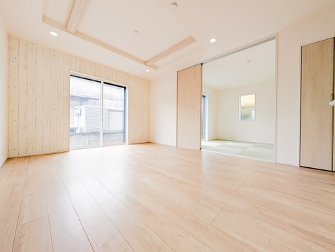 木目調アクセントクロスが印象的なリビング。遊び場や来客時に便利な和室が隣接しています。