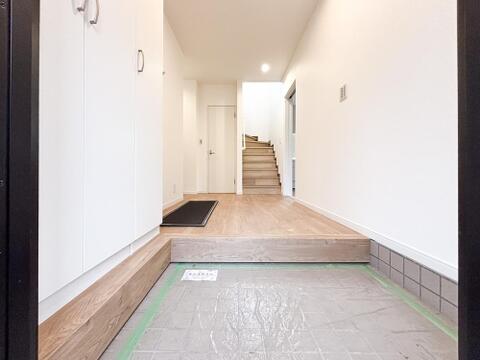 リノベーションにより美しく生まれ変わった玄関。白と木目を基調とした明るい空間が広がります。大型のシューズボックス完備で、家族の靴もすっきり収納可能です。