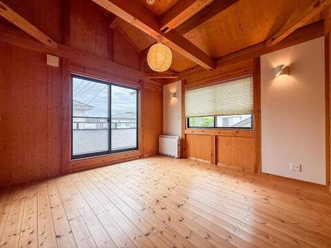 木のぬくもりを感じるフローリングと壁が心地よい居室。大きな窓から光が差し込み、お子様の遊び場や学習スペースに最適。