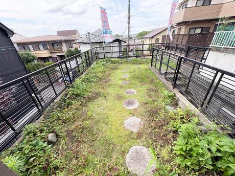 飛び石が配された庭は、お子様との遊び場やガーデニングに最適です。周囲をフェンスで囲まれ、プライベート感も確保。住宅街の眺望も楽しめ、家族の憩いの場となるでしょう。