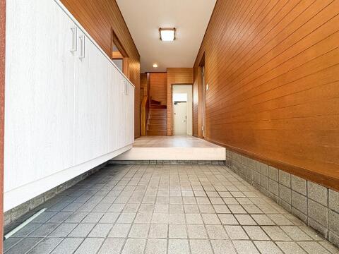 木の温もりを感じる壁面と、白いシューズボックスが調和する広々とした玄関スペース。奥行きがあり開放的で、家族やゲストを心地よく迎え入れてくれる上品な空間となっております。