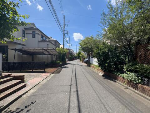 青空の下、緑豊かな並木道が続く閑静な住宅街です。お子様との散歩や家族での穏やかな暮らしに最適な環境が、日々の生活に彩りを添えます。