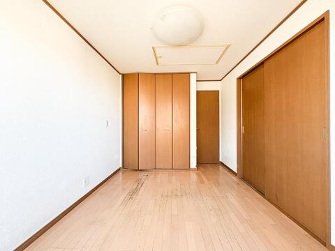 陽光差し込む明るい洋室。木目調フローリングと白壁が清潔感を演出する、心地よいプライベート空間です。