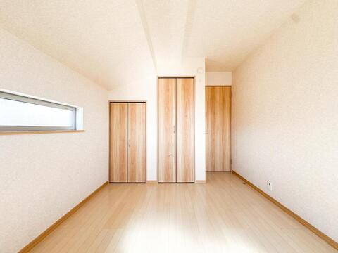 明るい陽光が差し込む洋室は、木目調のフローリングが温もりを演出します。豊富な収納スペースで、お子様の成長に合わせて様々に活用できるプライベート空間です。