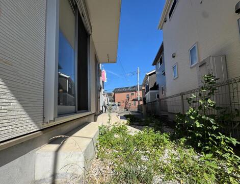 青空の下、陽光が降り注ぐ明るい住まい。建物の側面からも日当たりの良さが伝わり、家族の笑顔が輝く毎日を予感させます。