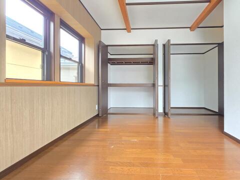 横並びの窓から自然光が差し込む洋室です。室内には2か所のクローゼットを備え、衣類や季節物などを分けて収納できます。梁を見せた天井も印象的で、収納力と居住空間の広さを両立した使いやすい一室です。