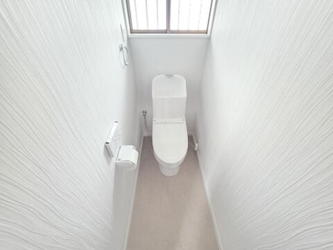 新規交換されたトイレは、温水洗浄機能を備えた使いやすい設備です。窓から自然光を取り込みやすく、換気にも配慮されています。壁紙や床も整えられ、毎日気持ちよく使用できる清潔感のある空間です。