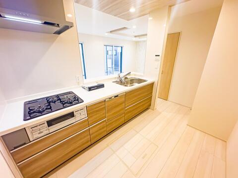 笑顔がよく似合う、そんな明るい雰囲気のキッチンスペース。毎日の料理が楽しくなりそうな期待感に満ちています。食洗器・浄水器・床下収納を完備。室内(2026年8月)撮影