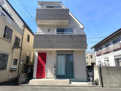 2010年築の3階建住宅。道路側に2層のバルコニーを設けた立体感のある外観で、各階に窓を備えています。玄関から居室まで縦に空間が広がる建物形状で、二世帯住宅としても利用できる住まいです。