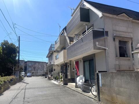 前面道路と建物の位置関係が分かりやすい一枚です。周辺には戸建住宅や集合住宅が並び、道路沿いには植栽も見られます。建物前面の道路には開放感があり、三鷹市上連雀の落ち着いた住宅街の様子が伝わります。