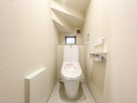 小窓・ペーパーホルダー棚付きの清潔感あふれるトイレ。手洗い一体型で省スペースな設計です。