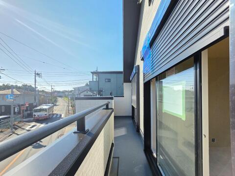 2部屋から出入りできる続きバルコニーは、各室から屋外へつながる配置です。建物の外壁に沿って奥行きがあり、外に出て気分転換する場所にも使えます。写真では手すり越しに周辺の街並みをご確認いただけます。