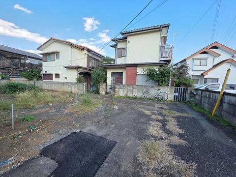 敷地前から道路の奥まで見渡した現地写真です。周囲の住宅の玄関や窓の位置も分かり、完成後の暮らしを考える参考になります。建物の配置図とあわせて、道路側からの視線もお確かめいただけます。