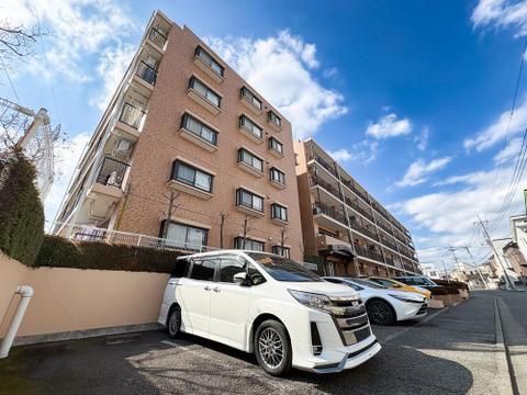 青空に映える重厚感あるタイル貼りの外観。手入れの行き届いた植栽が、管理体制の良さを物語ります。