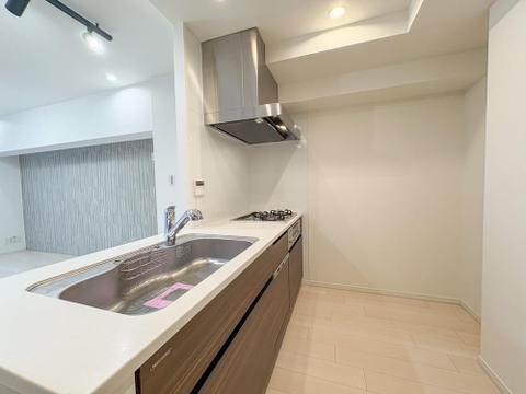 白を基調とした清潔感あふれるシステムキッチン。3口コンロと広々とした調理スペースで、毎日の家事がスムーズに。充実の収納力で、美しい空間を保てます。