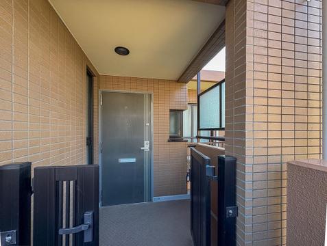 玄関前には専用の門扉付きポーチを完備。共用廊下から一歩奥まった造りで、プライバシーをしっかり確保します。戸建て感覚を味わえる、独立性の高い玄関アプローチです。