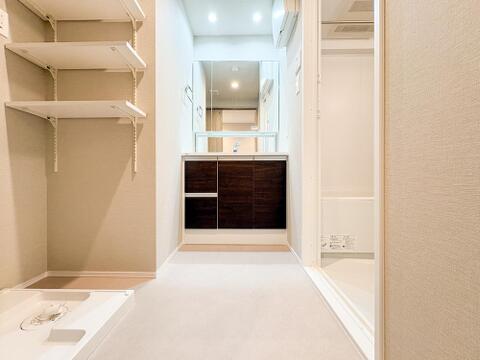 広々とした洗面脱衣所は、収納が豊富で家族みんなが使いやすい空間です。清潔感があり、日常の洗濯や着替えもスムーズに進みます。便利で快適な設計が魅力となります。