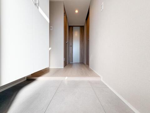 玄関スペースはシンプルでありながら上品なデザインが特徴。来客時にも好印象を与える清潔感があり、収納も備わっているため、靴や小物もすっきり片付けられる使い勝手の良い空間です。