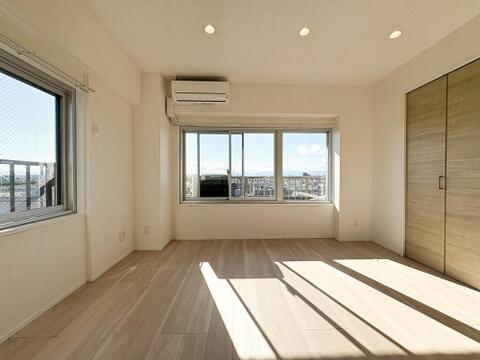 陽光差し込む明るい洋室。木目調フローリングと白壁が清潔感を演出する、心地よいプライベート空間です。