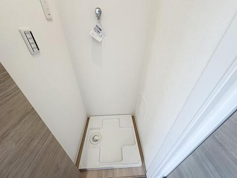 洗濯機置場は、お手入れのしやすい防水パン付き。上部には便利な給水蛇口も完備されています。無駄のないスッキリとした空間で、日々の家事動線もスムーズな設計です。