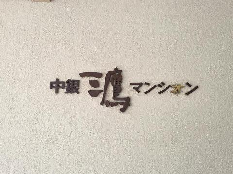 マンション名が掲げられたエントランスは視認性が高く、来訪者にも分かりやすい設計です。落ち着いた外観と調和した佇まいが、建物全体の印象を引き締めています