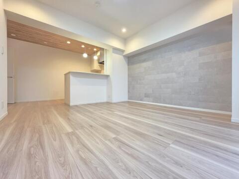 対面式カウンターキッチンを採用したLDKは約14.2帖の広さがあり、室内を見渡せる配置です。フロアタイル施工とアクセントウォールにより統一感のある空間に仕上がっています