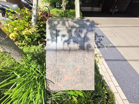 調布多摩川サニーコートの館銘板が設置されており、手入れの行き届いた植栽とともに落ち着いた雰囲気を演出しています。共用部の管理状態の良さが感じられ、住まう方への配慮が行き届いたマンションです。