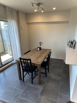 明るい陽光が差し込むダイニングスペース。温かみのある木製テーブルとスタイリッシュな床タイルが調和し、家族の会話が弾む食卓を演出します。笑顔あふれる毎日を過ごせる、心地よい空間です。