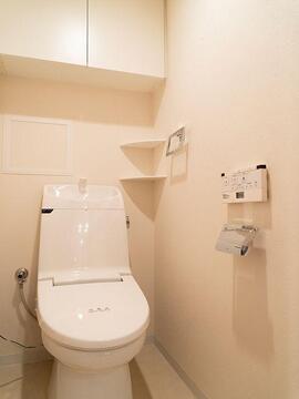 清潔感あふれる温水洗浄便座付きのトイレです。トイレットペーパーや掃除用品を生活感を隠して収納できる上部吊戸棚を設置。