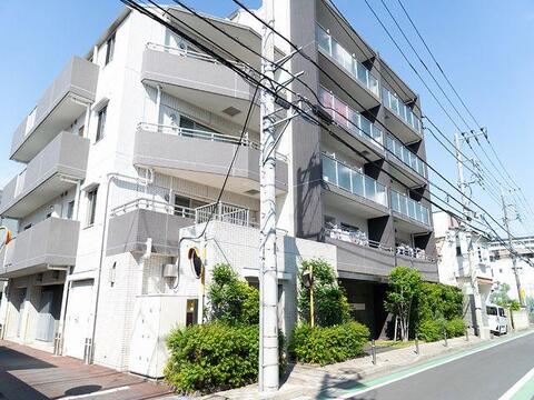 白とダークトーンを基調とした洗練された外観フォルム。モダンな佇まいと、建物を優しく包む豊かな植栽の緑が、周囲の穏やかな街並みと美しく調和しています。
