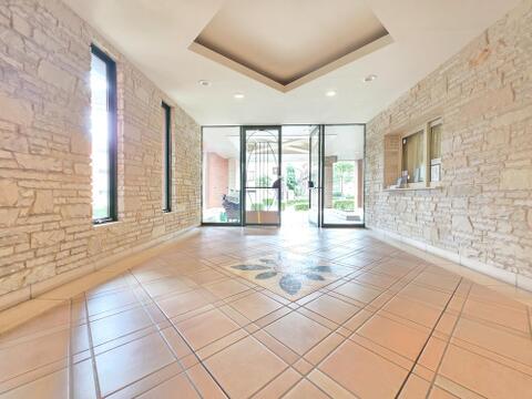 天然石調の壁面が上質な雰囲気を演出するエントランスホールです。ゆとりある広さと開放感のある空間が訪れる方を心地よく迎え、管理の行き届いたマンションならではの品格を感じられます。