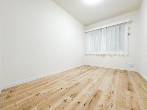 家具のレイアウトがしやすい整形の洋室。ベッドに加えてデスクや収納家具も配置しやすく、主寝室・子ども部屋・書斎など幅広い用途に対応。白を基調とした内装と木目調フローリングが、明るく開放感のある空間を演出
