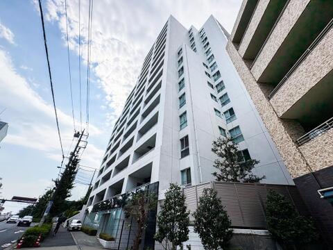 青空に映える白い外観が印象的なマンション。都市の利便性と快適な住環境を両立し、子育てファミリーに理想的な暮らしを提供します。