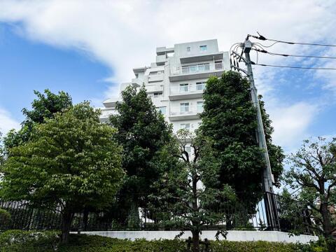 空の青と建物の白、そして豊かな緑のコントラストが美しい外観。自然を感じながら、家族との穏やかな時間を過ごせる住まいです。