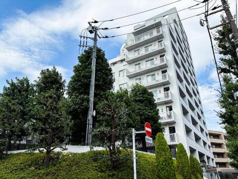 白い外壁が青空に映える、モダンなデザインのマンションです。豊かな緑に囲まれ、落ち着いた住環境で家族の毎日を育みます。