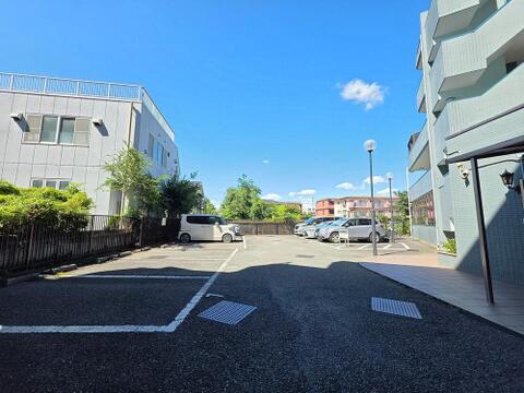 ゆとりある敷地内駐車場を備え、車の出し入れもしやすい配置です。建物まわりには開放感があり、住戸へのアプローチにもゆとりが感じられる、落ち着いた住環境が広がっています。
