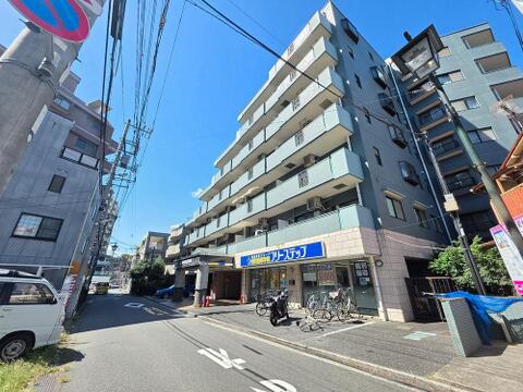 前面道路から建物全体を望める現地です。歩道が整った道路に面し、駅徒歩3分の利便性を享受しながら、周辺には買物施設や生活利便施設が身近に揃う住環境も魅力です。