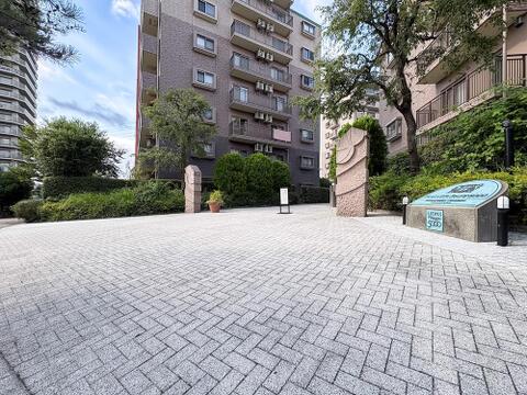 重厚感漂う銘板と広々とした石畳の敷地アプローチ。住まいの格調高さを際立たせる綺麗なエントランスです。