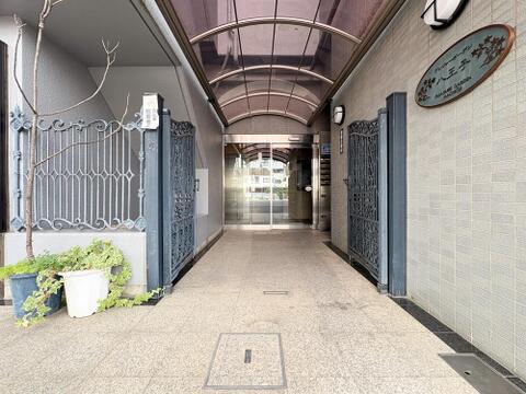 趣のあるアイアンゲートと植栽が迎えるアプローチ。屋根付きの設計で雨の日の出入りも安心・快適です。